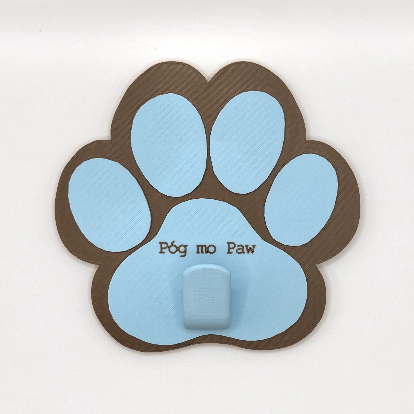 Brown and blue paw-shaped standard leash holder with Póg mo Paw text and single hook for leads and collars
