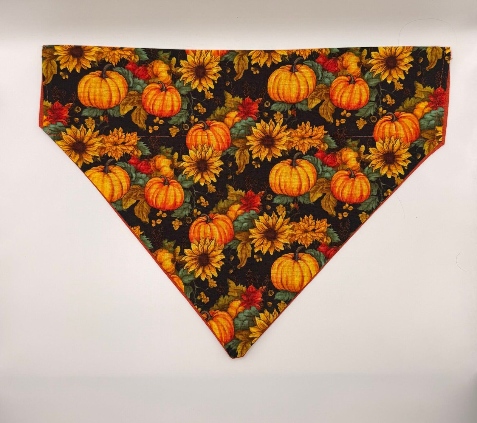 Pumpkin Patch dog bandana with orange pumpkins and sunflowers on black background, collar-through sleeve